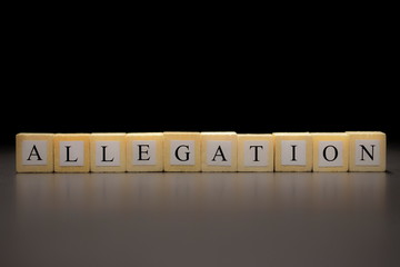 The word ALLEGATION written on wooden cubes isolated on a black background...