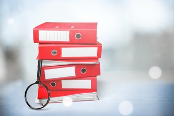 File folders with documents and magnifying glass on the desk