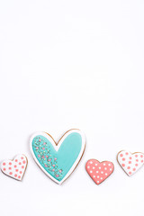 Gingerbread cookies with frosting in the shape of a heart on white background. Valentines day concept. Flat lay, top view, copy space for text.