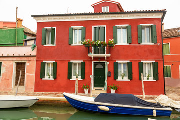 Fototapeta na wymiar Venice landmark, Burano island canal, colorful houses church and boats, Italy.