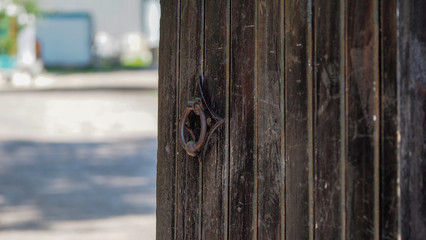 Closeup image of old door with circle iron door-handle. old metal handle on a wooden door