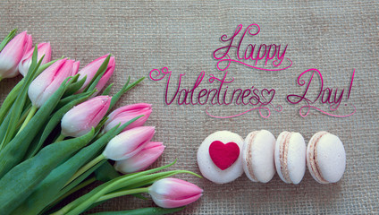 Valentine's day background with tulips bouquet and pink macarons.
