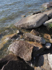 Waves breaking on stones on the lake shore with a splash and fast motion