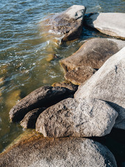 Waves breaking on stones on the lake shore with a splash and fast motion