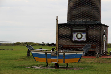 blick auf ein boot und den leuchtturm auf der nordsee insel juist in nord deutschland