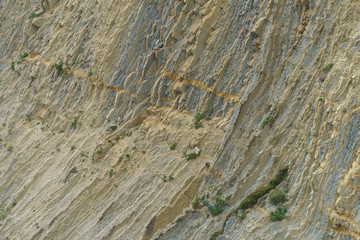 Photography of stone texture. Detail of cliff in Zumaia in Basque Autonomous Community / country in summer cloudy day in Bay of Biscay. Ornamental pattern of mountain surface. High resolution image.