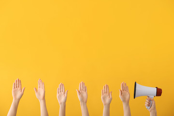 Many hands with megaphone on color background