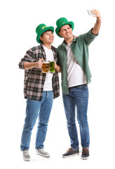 Young men with beer taking selfie on white background. St. Patrick's Day celebration