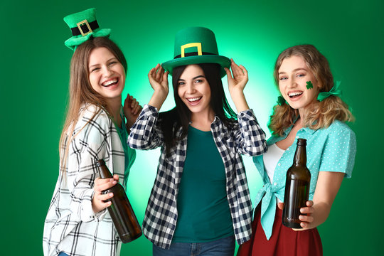Young women with beer on color background. St. Patrick's Day celebration
