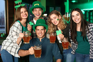 Young friends celebrating St. Patrick's Day in pub