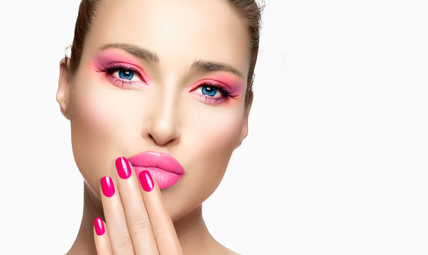 Close-up face of beauty model with colorful pink make-up. Fashion makeup and cosmetics concept.