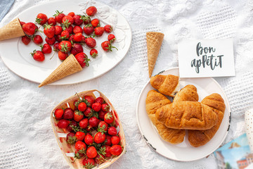 A plate of ripe juicy red strawberries and a waffle cone. Still life of summer delights