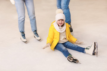 Cute little girl after falling on skating rink