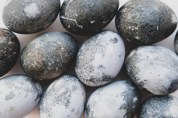 Natural dyed eggs on white background, close up.