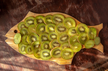 thin circles of kiwi on a wooden board