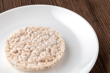 Rice cakes on a white plate on a wooden table