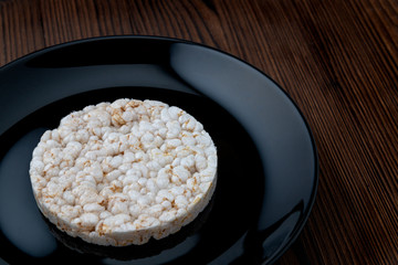 Rice cakes on a black plate on a wooden table