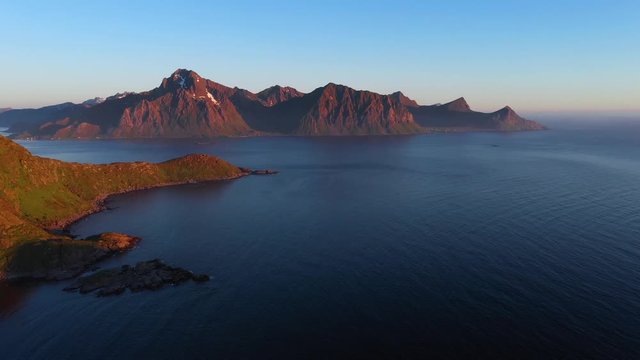 aerial view. flight over the sea,view on the Flakstadoya from Haukland beach and Mannen peak. Camera move left to right .Lofoten Islands,Norway
