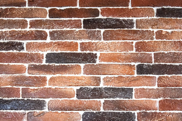 Obraz premium Fragment of an old brick wall. The texture of the brickwork of different colors: red, brown. Selective focus.