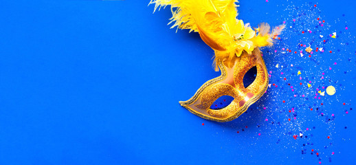 Carnival mask on blue background with sparkles. Mardi gras concept. Copy space © Nataliia