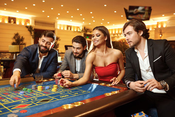 Young woman makes a bet at the casino roulette poker.