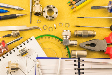 Abstract engineering and technology yellow background featuring details of researcher table with components, records and tools for development process in applied science