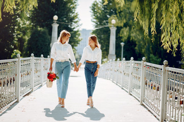 Elegant mother with young daughter. Family in a park. Women with a bouquet of flowers