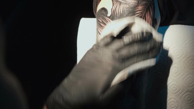 Close up video of doing black tattoo of snake in studio