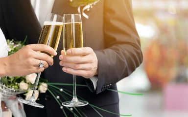 Young beautiful couple in the wedding day with glasses of champagne