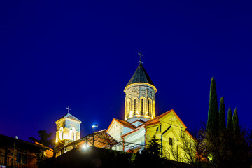 Georgia, Tbilisi all Saints Church at sunset on a winter evening. The dark blue sky. The temple is lit by lanterns