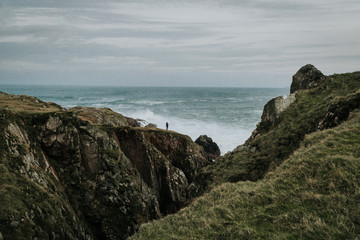 Atlantic Ocean with waves and rocks on which man is