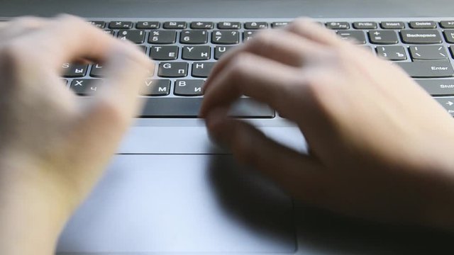 The boy's hands are typing on the keyboard. Education.