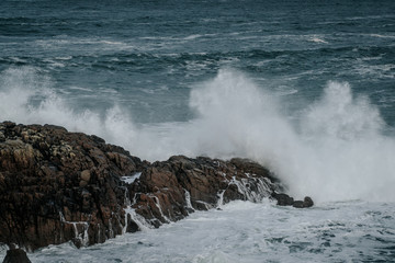 The waves of the ocean hit the rocks with small splashes