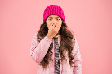 Flu season. Sneezing. Cold climate weather. Little girl sick ill pink background. Kid puffer jacket...