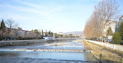 river in the city center with mountains on the horizon