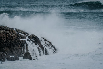 The waves of the ocean hit the rocks with small splashes