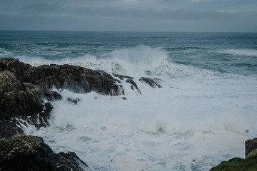 The waves of the ocean hit the rocks with small splashes