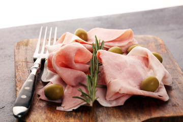 Sliced ham on wooden background. Fresh prosciutto. Pork ham sliced. pork meat cutting