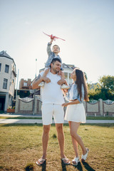 Obraz premium Family in a summer park. Father in a white shirt. Cute little son with airplane