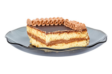 Quarter of shortbread cake with chocolate glaze and decorated by cream ornament on top on a saucer of dark smoky glass isolated on a white background