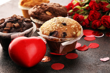 chocolate muffins, blueberry muffin and nut muffins on dark background for Valentine's day....