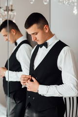Morning groom in the room. Wedding photography. Groom getting ready in the room for wedding day. Details. Fees of the groom.