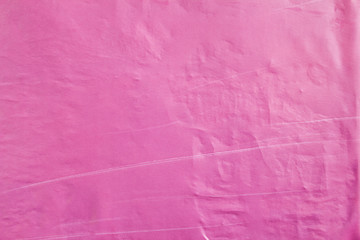 Purple crumpled and scratched poster glued on street billboard. Purple wavy paper placard texture...
