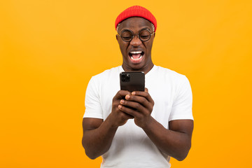 American man is very surprised looking at the screen of his smartphone