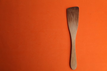 wooden cooking spatula in color background