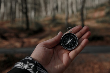 The compass in my hand is in the background FOREST, Compass, navigational compass, travel compass, lost compass,
