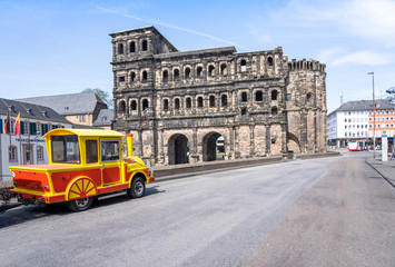 Train near the Porta Nigra entrance gate town in Trier, Germany