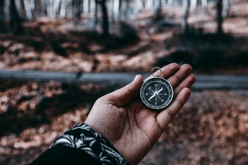 The compass in my hand is in the background FOREST, Compass, navigational compass, travel compass, lost compass,
