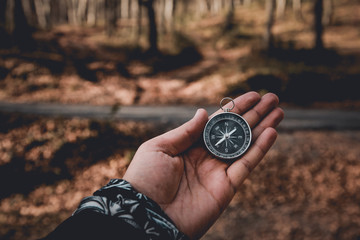 The compass in my hand is in the background FOREST, Compass, navigational compass, travel compass, lost compass,
