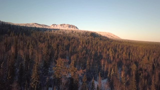 Beautiful view of the mountains forest at sunset in winter with a quadrocopter drone